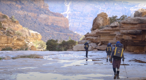 Camp Omega participants backpacking through a canyon